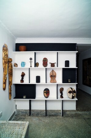A display of various cultural artifacts on shelves. - Sunset Villa at Forest Hill House (LUSAKA)