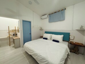 Une chambre à coucher avec un lit, un bureau, une chaise, une porte bleue et un climatiseur fixé au mur.