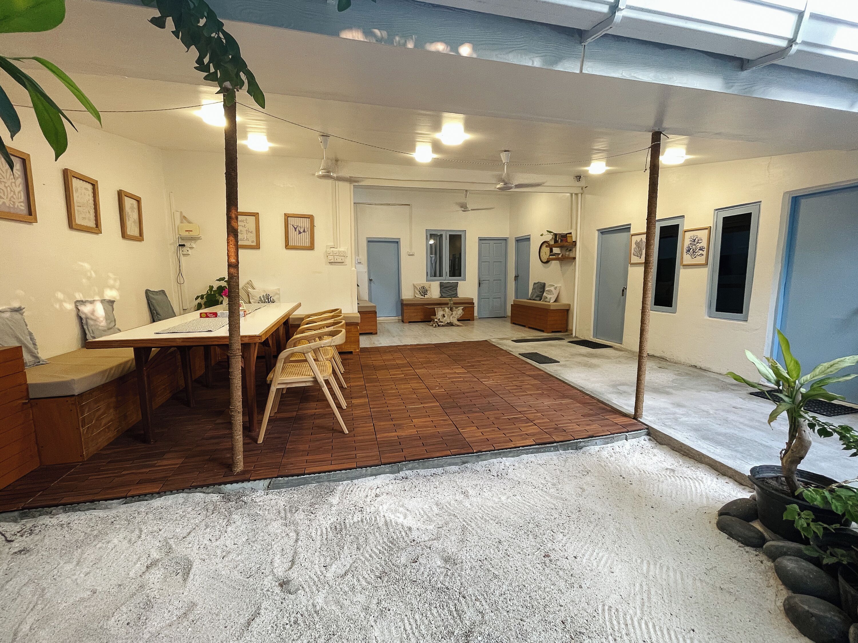 Una habitación amplia con comedor, zona de estar y un pasillo que lleva a una puerta.