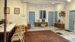 Una habitación con una mesa de comedor, sillas, un banco y un ventilador de techo.