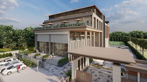 Un hotel moderno con tejado plano, amplias ventanas y un área exterior cubierta con sombrillas.