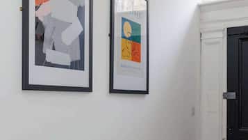 Ein Flur mit zwei gerahmten Kunstwerken an der Wand und einer Tür am Ende.