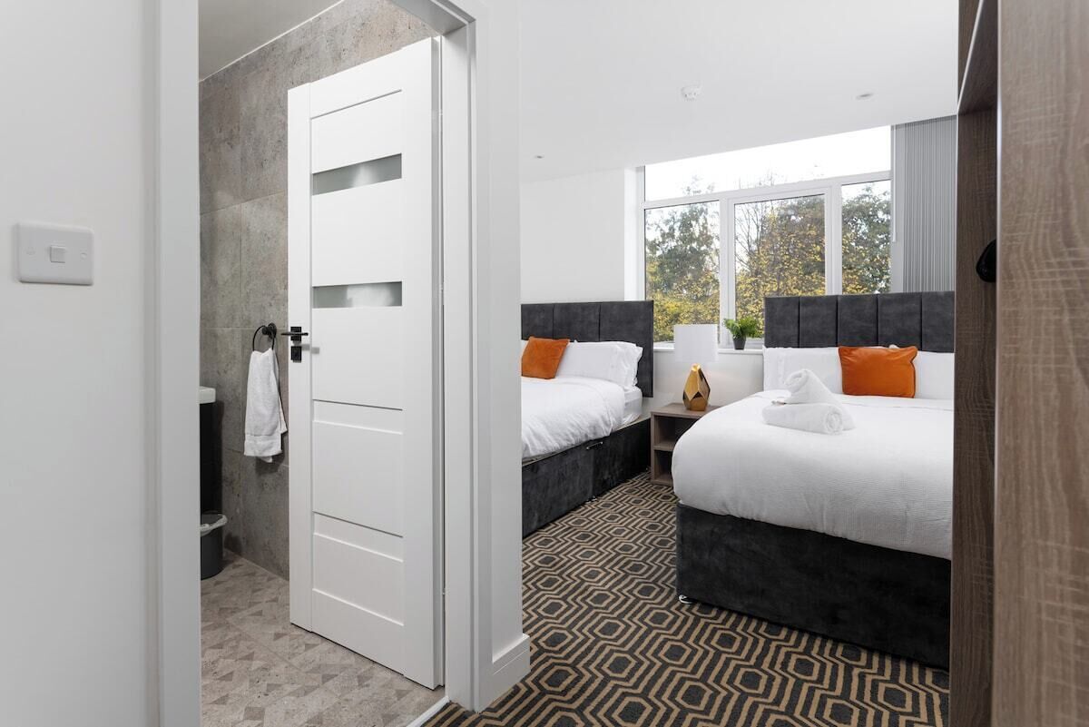 A hotel room with a large bed, a smaller bed, and a walk-in closet.