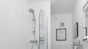 A modern bathroom with a bathtub, shower, toilet, and sink. - Flatzy - Iconic Beatles and Liverpool Culture Home (Liverpool)