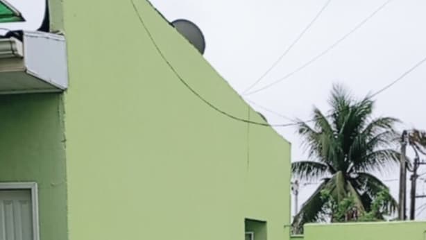 Un bâtiment doté d’une façade incurvée, d’une porte et d’une petite fenêtre.