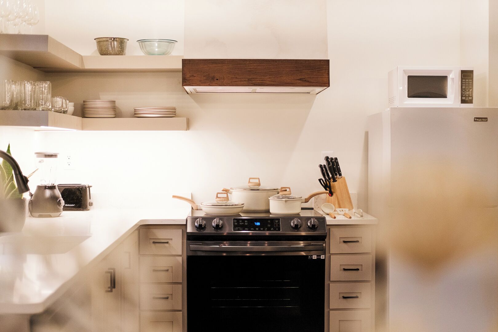 Una cocina equipada con estufa, horno, microondas y diferentes utensilios de cocina.
