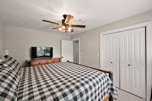 A bedroom with a bed, a television, a ceiling fan, and a wardrobe. - King of Mountain: Hot Tub, Grill, Games, Pet-Friendly! (Gatlinburg)
