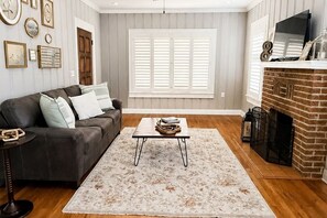 A living room with a sofa, coffee table, and fireplace.