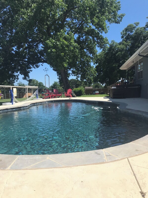 Ein Swimmingpool mit klarem Wasser, umgeben von einer Betonplattform.