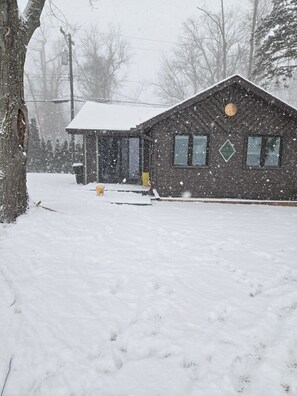 A snow-covered building with a single visible window and a door. - Cozy 1-bedroom cabin in amazing White Lake with AC on ALL SPORTS SUGDEN LAKE (White Lake)