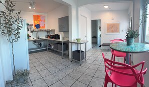 Une cuisine moderne avec un coin repas, comprenant une table avec des chaises et une plante décorative.