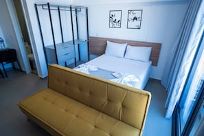 A hotel room with a bed, a sofa, a desk, and a wardrobe. - Vista Cecap (Guarulhos)