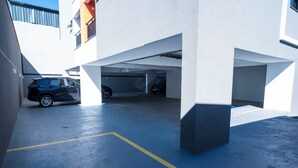 Un garaje con varios niveles y un automóvil estacionado en la planta baja.