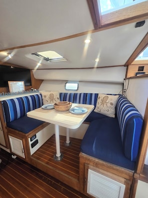 A compact interior with a dining area featuring a table and cushioned seating.