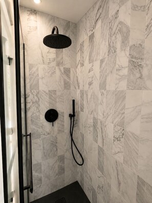 A shower area with a handheld showerhead and a wall-mounted control. - Modern Scandi Home on a Private Estate (Harbor Springs)