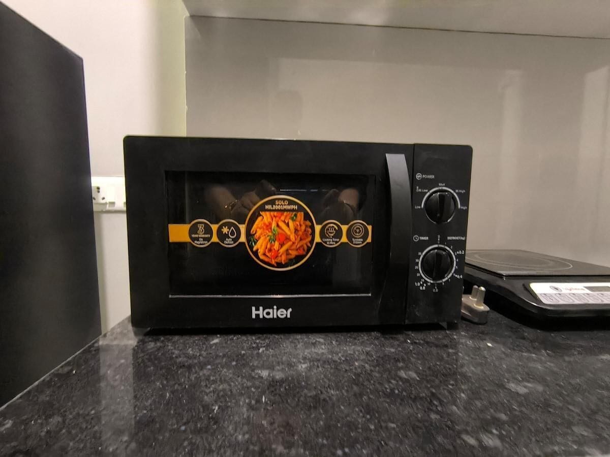 A Haier microwave oven on a granite countertop.