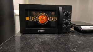 Un horno microondas Haier sobre una encimera de granito.