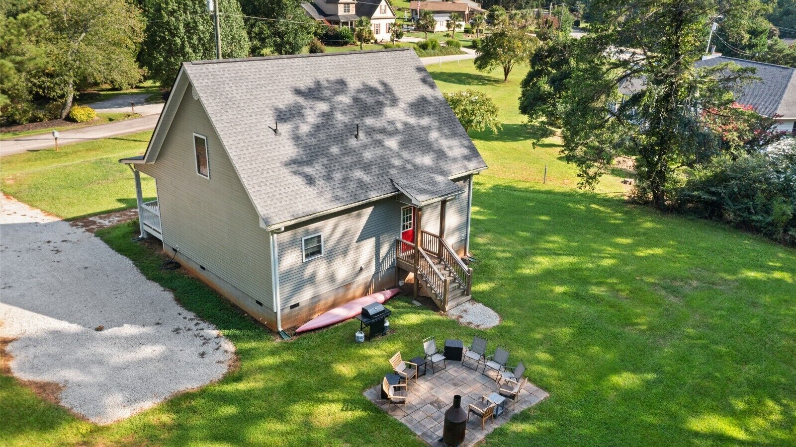 A single-story house with a covered patio area, a small deck, and a driveway.