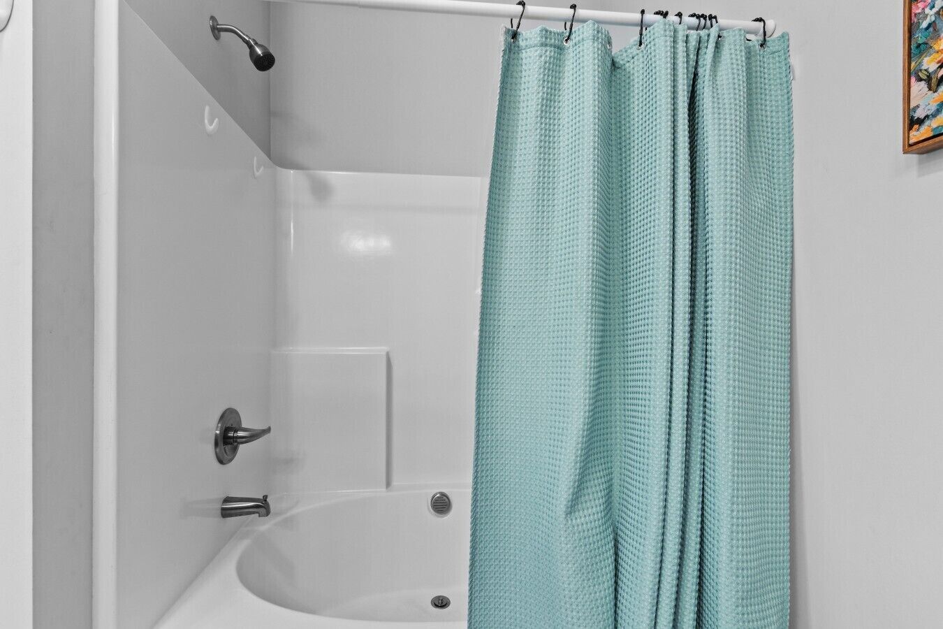 Ein Badezimmer mit einer Badewanne, einer Duschvorhang und einem Wasserhahn.
