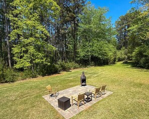 An outdoor patio with a wood-burning stove, seating, and a view of a forest. - Walk to Boat Ramp Lake Keowee w/ Parking + Firepit (Seneca)