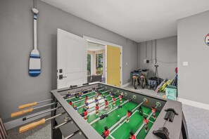 Et rum med et bordtennisbord, en moppe og en spand til moppen på gulvet.