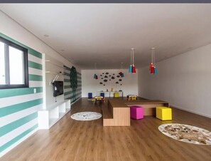 A modern interior with a wooden floor, a central wooden table, colorful blocks, and pendant lights. - Luxury Apartment in Alphaville Barueri (Barueri)