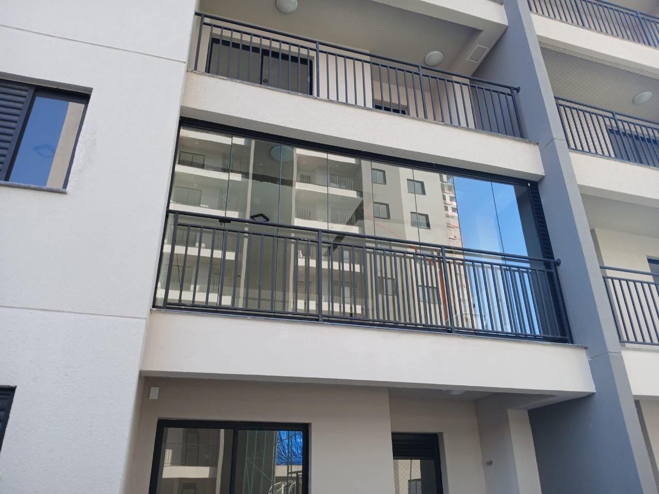 A multi-story building with balconies, large windows, and a flat facade.