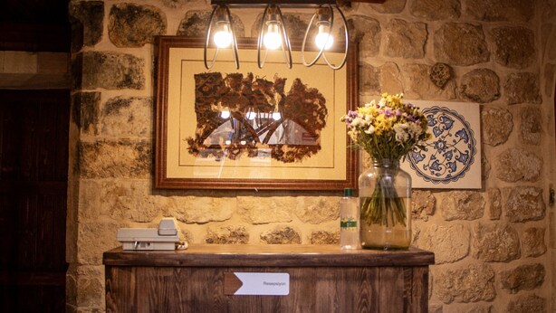 Una recepción con una obra de arte enmarcada, un jarrón con flores y un plato decorativo en la pared.