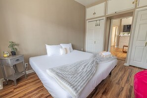 A bedroom with a bed, bedside table, and a potted plant. - Cozy Mount Washington 1BR with Private Patio (Pittsburgh)