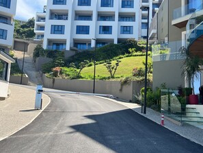 Ein modernes Gebäude mit mehreren Balkonen und einem angelegten Garten.
