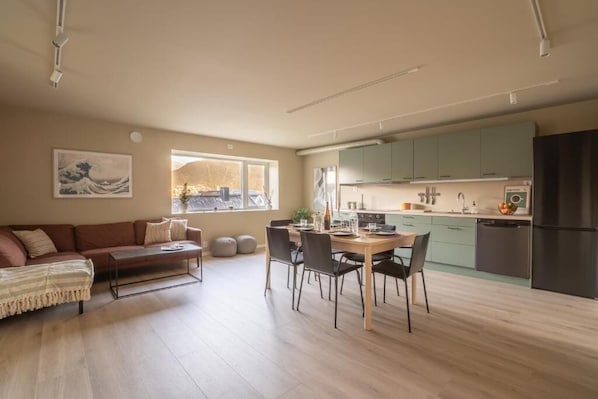 A modern living space with a dining area, kitchen, and a sofa set. - Luxury top floor apartment (Troms)