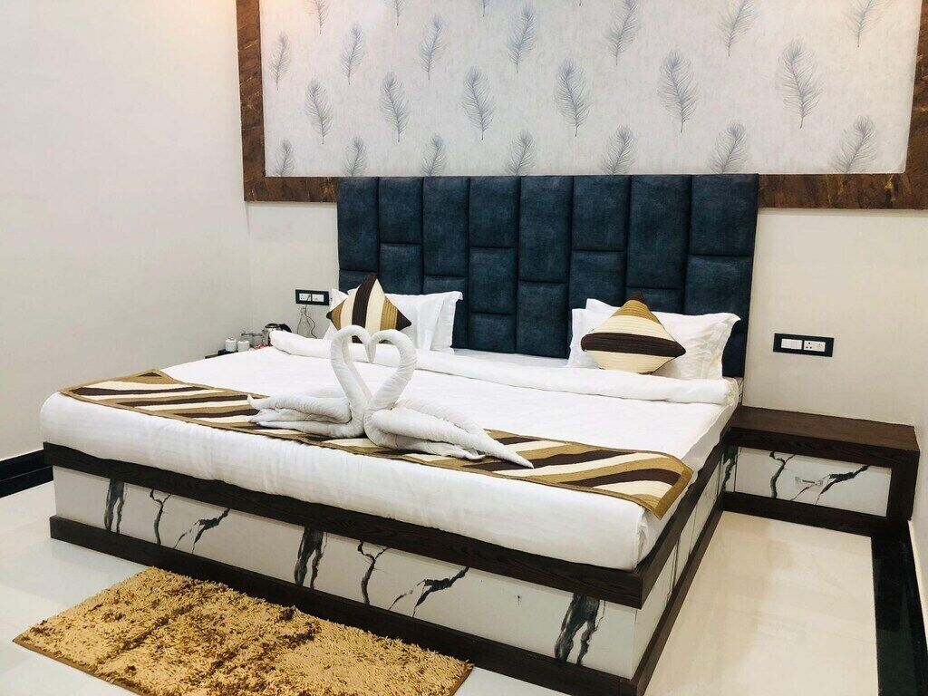 Un dormitorio con cama, cabecera, almohadas y una obra de arte colgada en la pared.