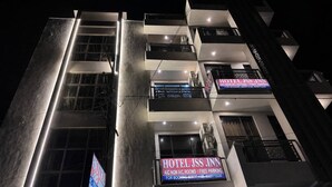 Un hotel de varios pisos con señalización iluminada, balcones y un diseño arquitectónico moderno.