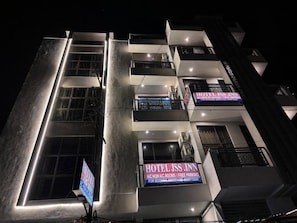A multi-story hotel with illuminated signage, balconies, and a modern architectural design.