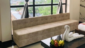 Una habitación con sofá, una mesa con fruta y vistas amplias a través de grandes ventanales.
