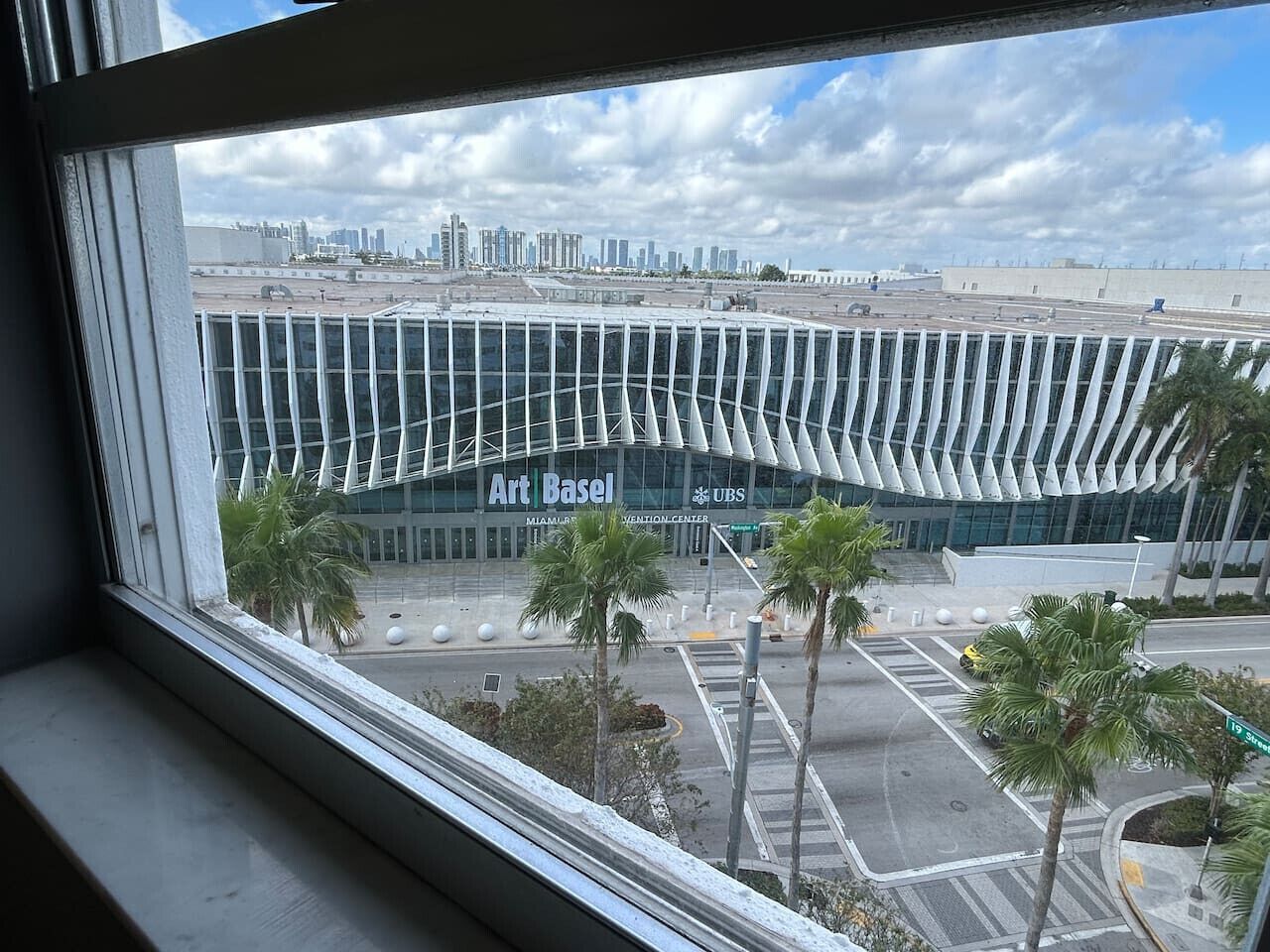 A view of Art Basel Miami Art Fair with modern architecture and palm trees.