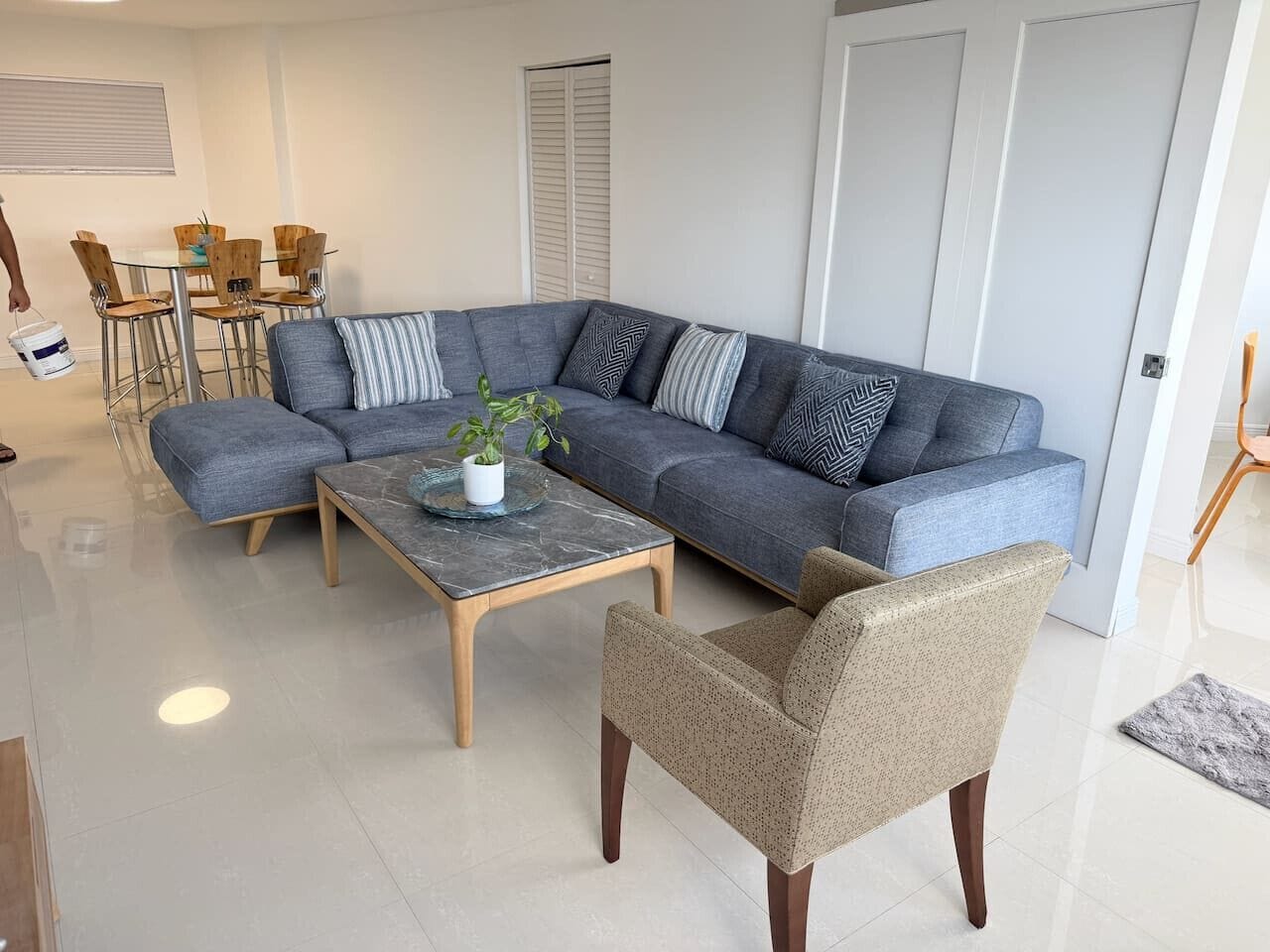 Una sala moderna con un sofá modular, una mesa de centro y un sillón.