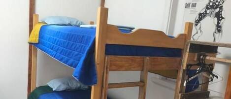 A bunk bed with a wooden frame and blue bedding.