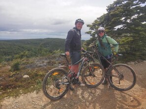 Two people standing on a dirt path with bicycles, surrounded by a natural landscape. - Casa Bike (Punta Arenas)