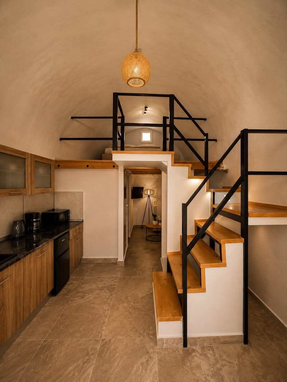 A modern kitchen with a wooden countertop, a coffee machine, and a black refrigerator.