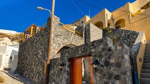 Um edifício de pedra com uma porta de madeira e uma escadaria que dá acesso a um andar superior.