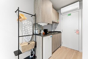 A compact kitchenette with a built-in oven, a small refrigerator, and a sink. - GuestReady - City centre stay in Porto (Porto)