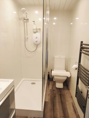Een moderne badkamer met een glazen douchecabine, toilet en bad.