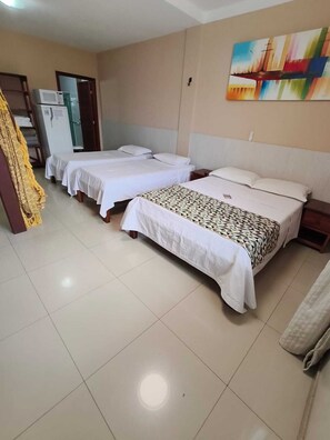A hotel room with two beds, a painting on the wall, and a refrigerator in the corner. - Pousada Praia Grande (Fundão)