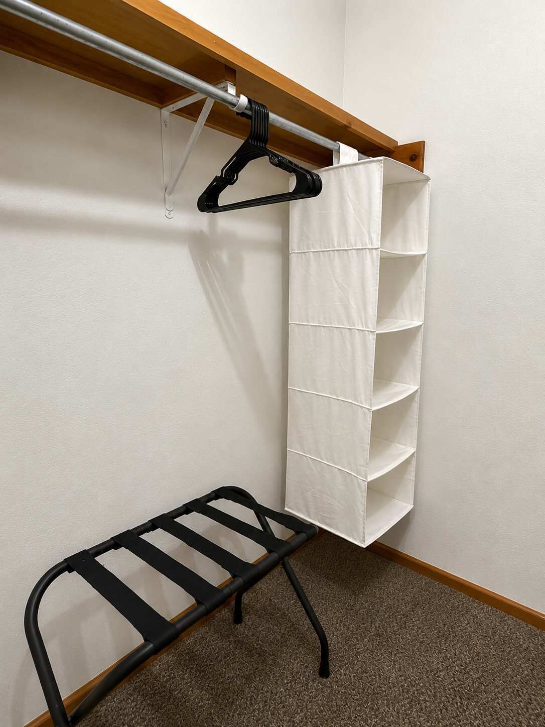 Ein Kleiderschrank mit Kleiderstange und Schuhregal.