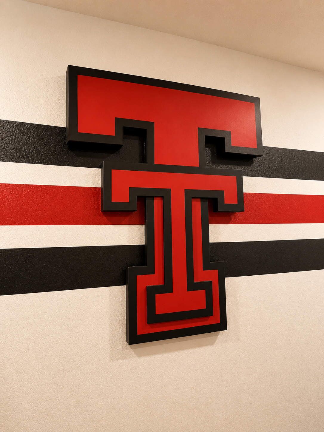A wall with a large, bold, red and black letter T design.