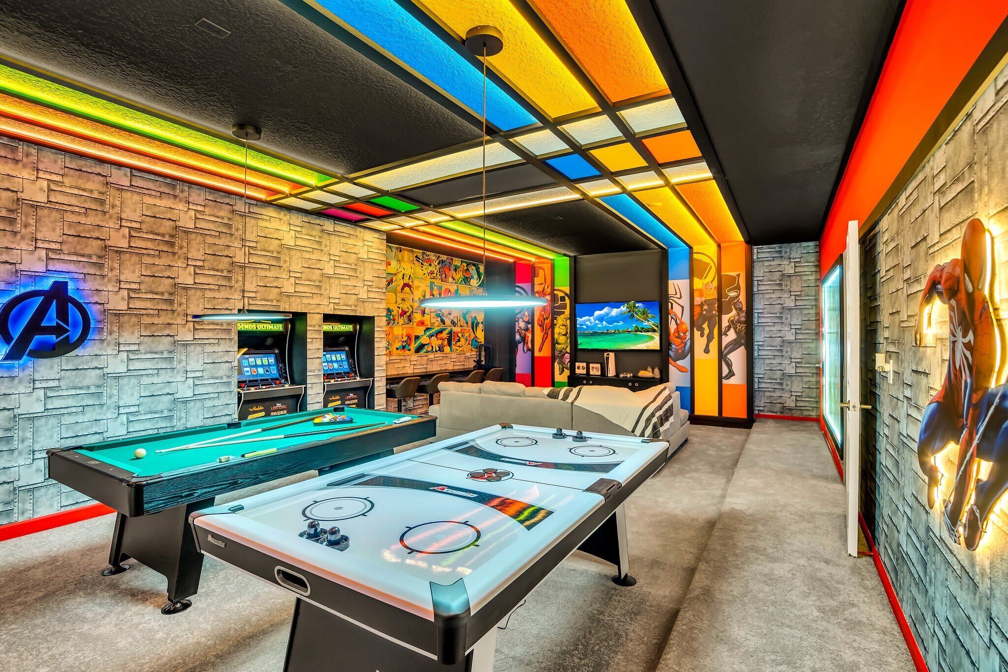 A pool table with a neon sign, a sofa, and a wall with a mural.