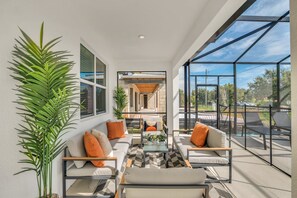 Ein modernes Interieur mit einer Sofagarnitur, einem Couchtisch und einem großen Fenster mit Blick ins Freie.