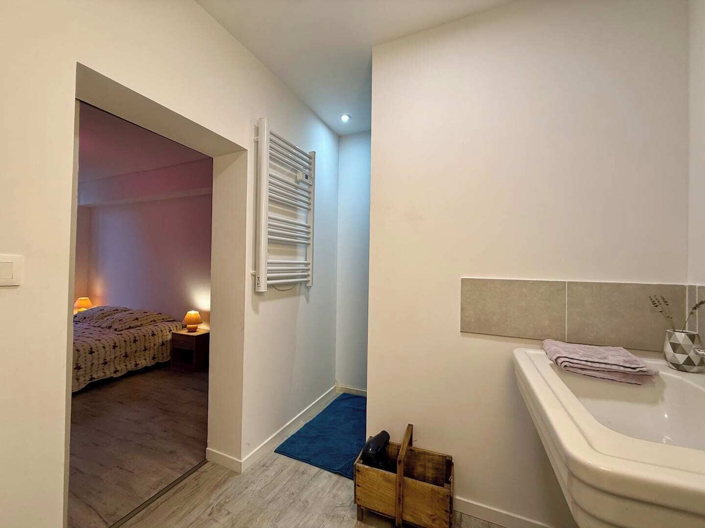 Une chambre à coucher avec un lit, une lampe de chevet et un radiateur.