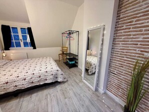 Una camera da letto con un letto, una sedia, un armadio e una finestra con tende.